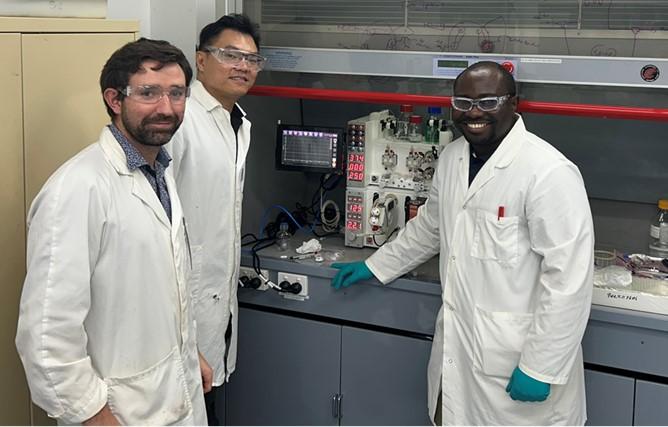 Chemists working on flow chemistry system during commissioning